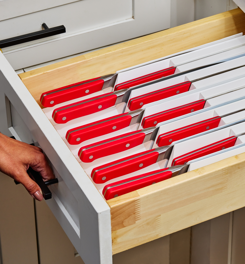 Kitchen drawer organizer with red-handled steak knives stored safely in divided slots